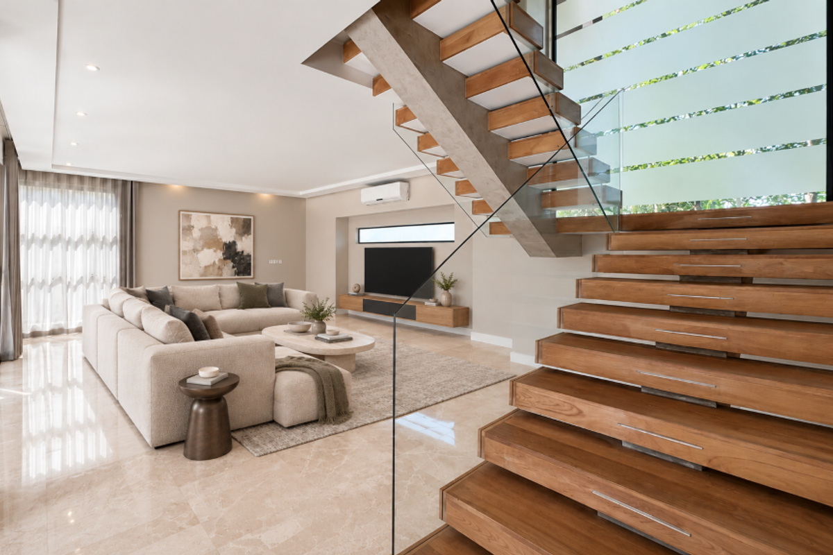 Modern open-plan living area featuring high-end marble flooring, a striking floating timber staircase with glass balustrade, and integrated media cabinetry.