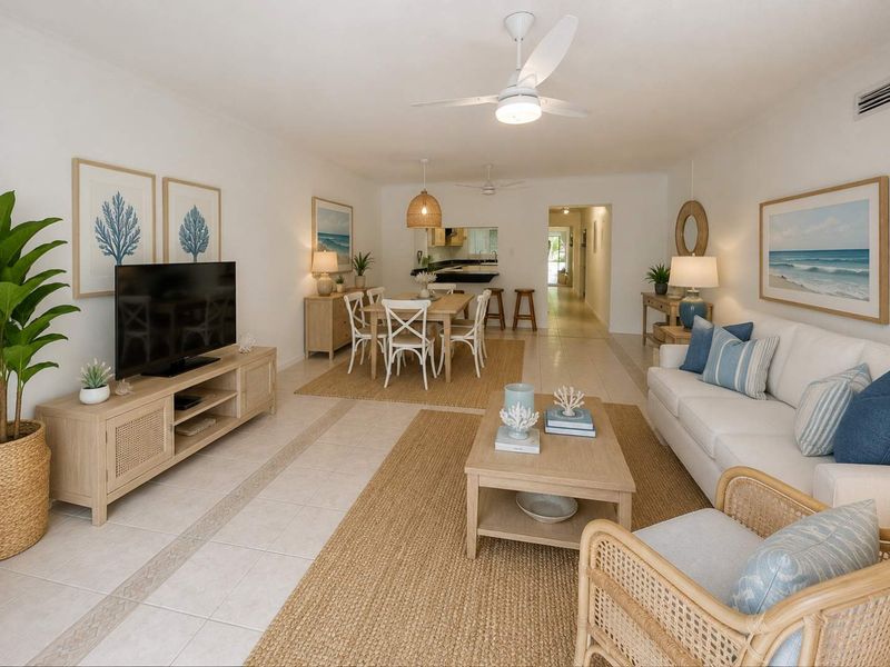 Spacious open-plan living and dining area featuring neutral tiled flooring, ceiling fans, and a convenient pass-through window connecting to the kitchen.
