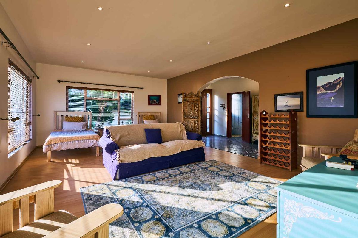 Spacious bedroom featuring laminate flooring, recessed downlighting, and an arched entryway leading to an adjacent tiled area.
