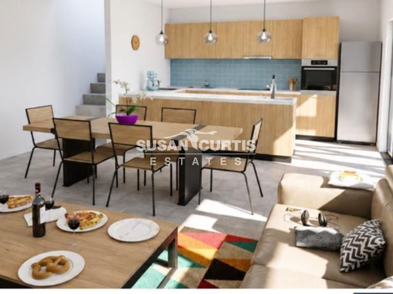 Modern open-plan living area featuring a contemporary kitchen with light wood cabinetry, integrated appliances, and seamless flow to the dining and lounge spaces.