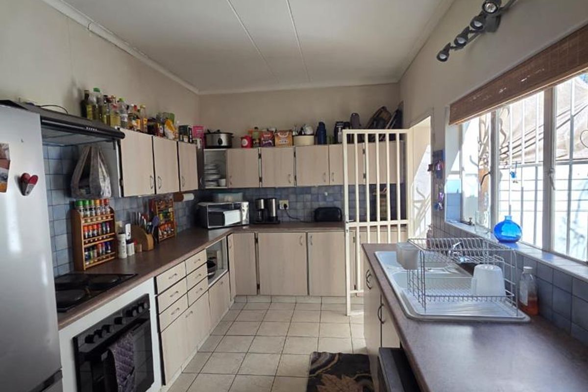 A functional kitchen featuring tiled flooring, ample built-in cabinetry, a tiled backsplash, and a built-in oven with hob.