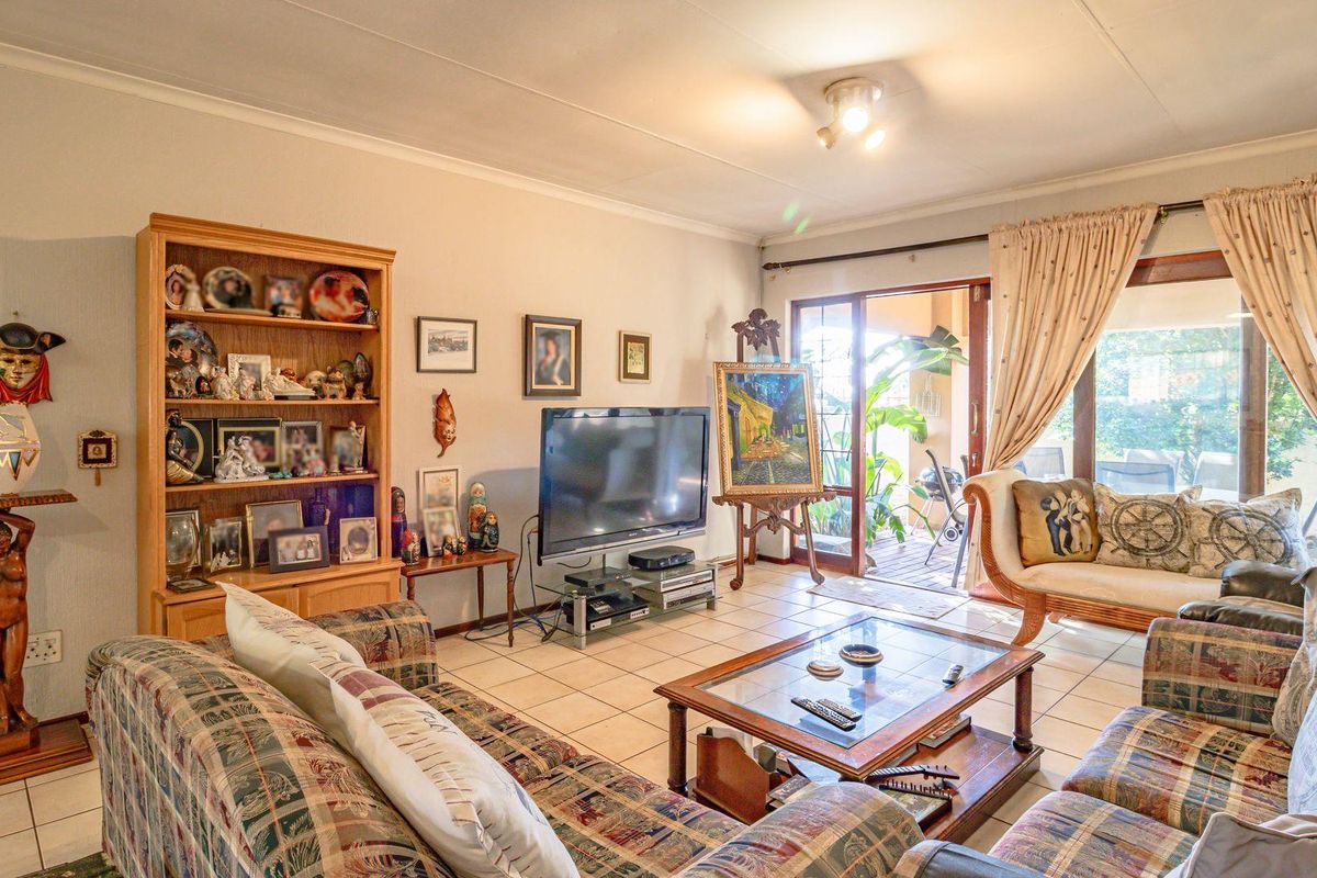 Spacious living room featuring tiled flooring and large sliding glass doors providing direct access to the outdoor patio area.