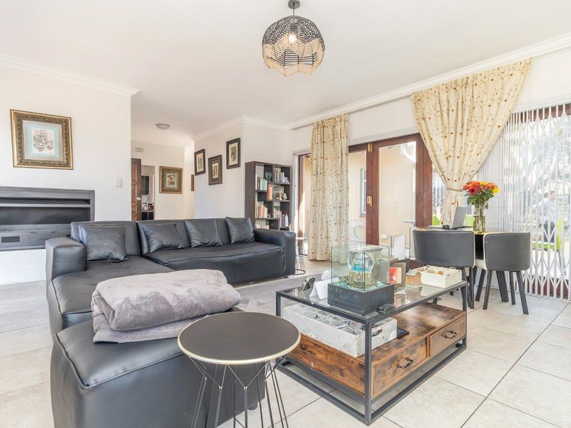 Spacious living room featuring tiled flooring, a built-in fireplace, and sliding glass doors providing access to the outdoor area.