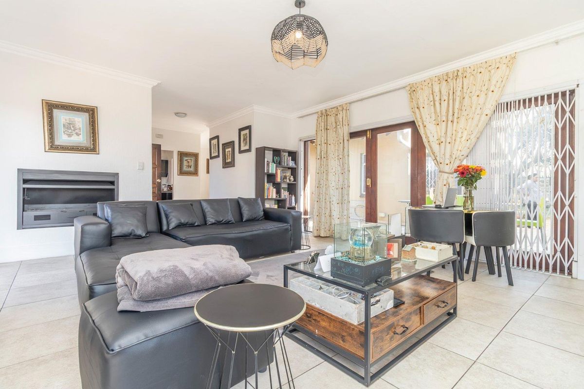 Spacious living room featuring tiled flooring, a built-in fireplace, and sliding glass doors providing access to the outdoor area.