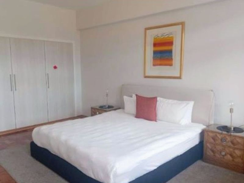 A well-maintained bedroom featuring neutral walls and spacious built-in cupboards, providing ample storage and a clean, functional living space.