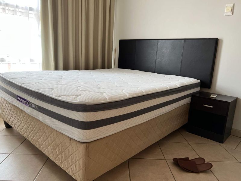 A bedroom featuring tiled flooring and neutral curtains, providing a functional space for rest.