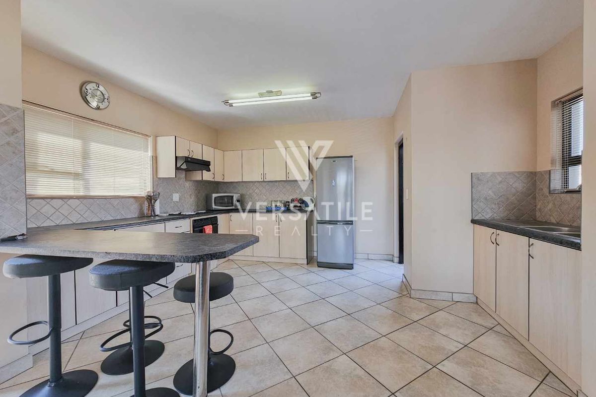 Functional kitchen featuring built-in cabinetry, laminate countertops, a breakfast bar, and tiled flooring, offering a practical layout for daily meal preparation.