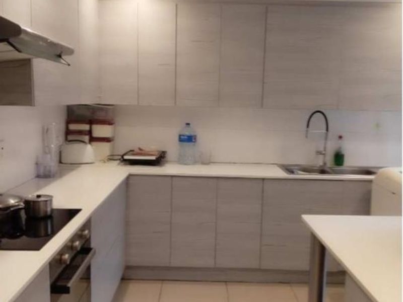 Modern kitchen featuring light wood-grain cabinetry, white countertops, integrated appliances, and tiled flooring with recessed lighting.