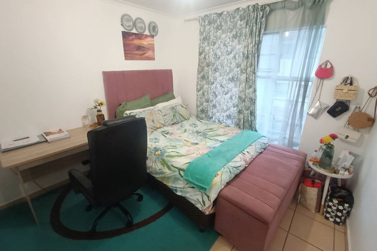 A compact bedroom featuring tiled flooring and a window with curtain tracks, providing a functional space for rest and study.