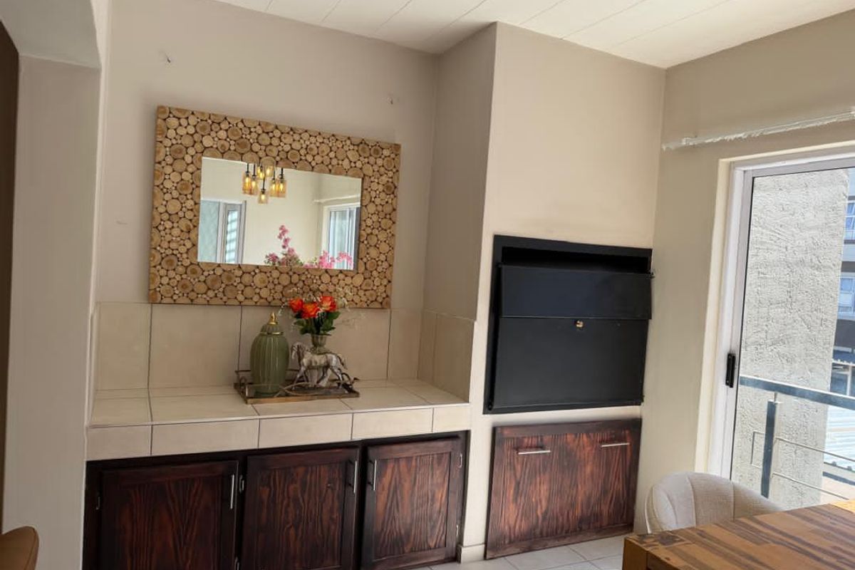 Living area featuring a built-in fireplace, tiled countertop cabinetry, and sliding door access to a balcony.