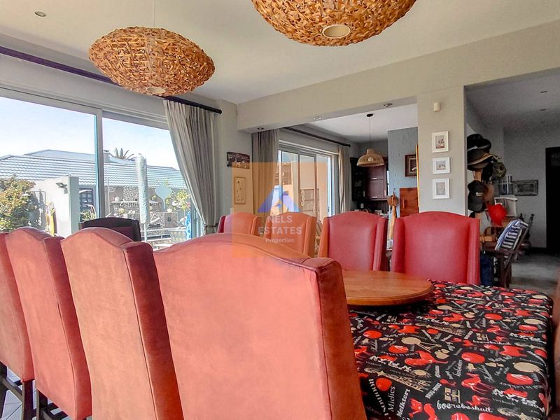 Spacious open-plan living and dining area featuring large sliding glass doors that provide ample natural light and seamless access to the outdoor space.
