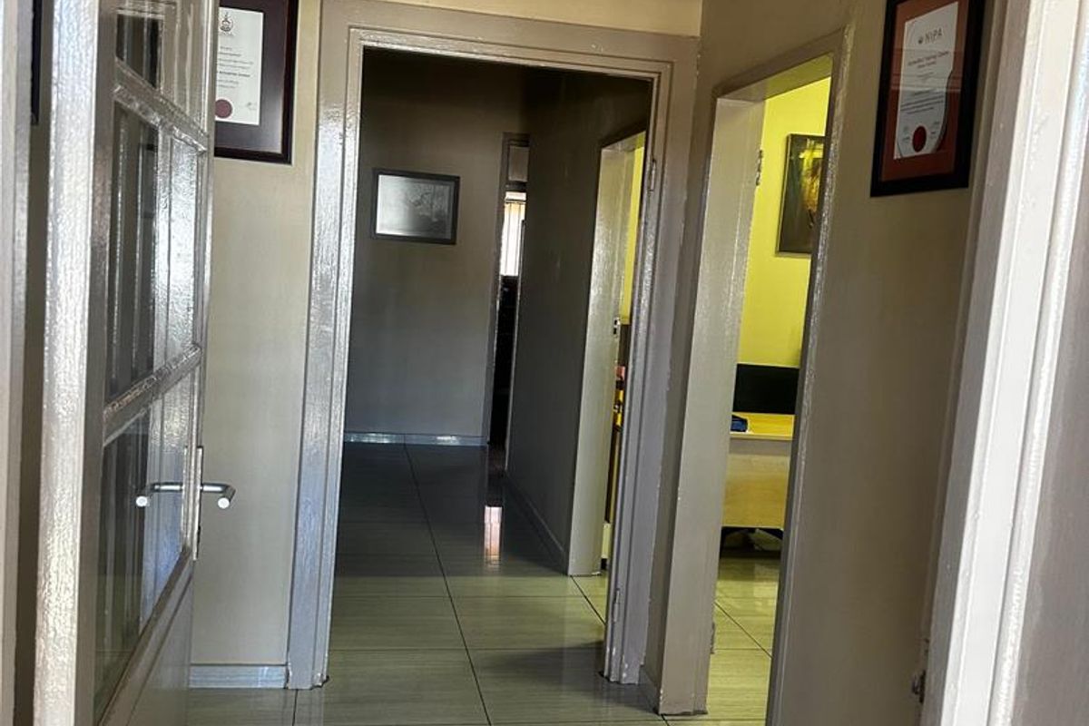 A functional hallway with tiled flooring connecting multiple rooms, featuring neutral wall tones and standard door frames.