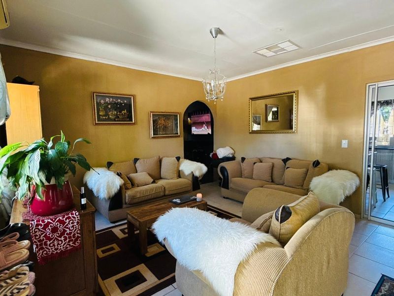 A living room featuring tiled floors, an arched doorway, and a sliding glass door leading to an outdoor area.