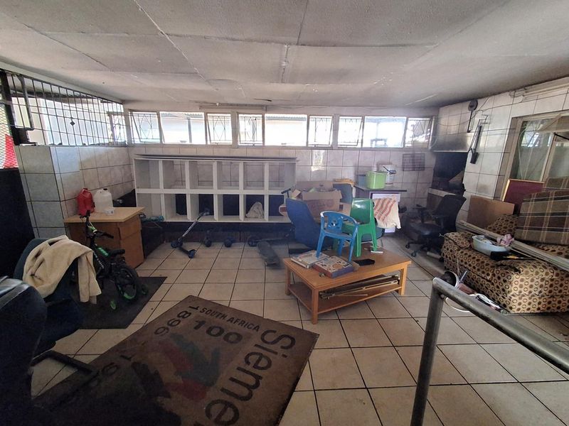 Enclosed patio area featuring tiled flooring, wall tiling, and a built-in braai, offering potential for a functional outdoor entertainment space.