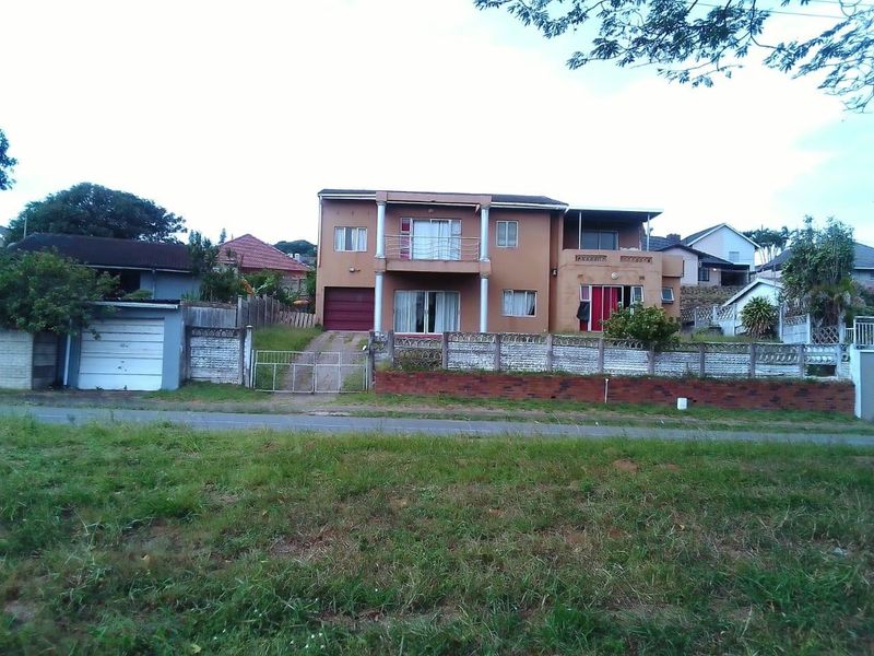 Front elevation of a double-storey residential house featuring a balcony, integrated garage, and perimeter boundary walling.