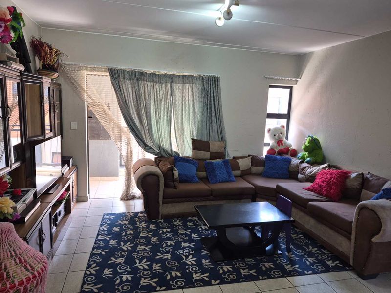A living room featuring tiled flooring and a sliding glass door providing access to an outdoor area.