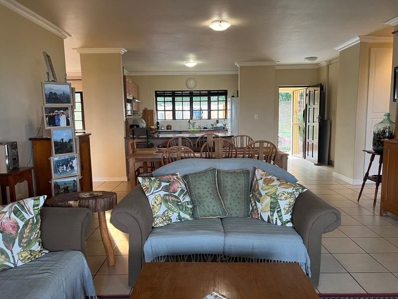 Open plan living and dining area featuring tiled floors, neutral walls, and a functional kitchen layout with direct access to the exterior.
