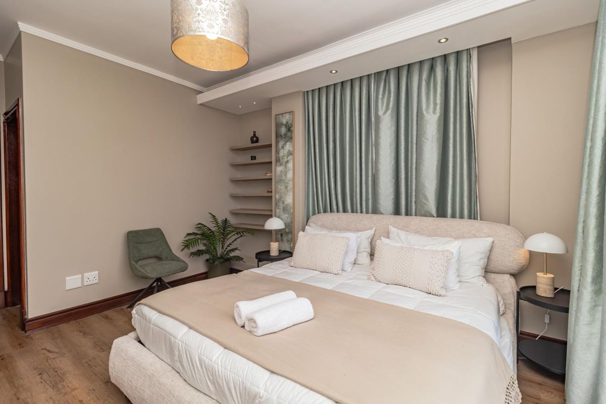 A well-maintained bedroom featuring built-in shelving, recessed ceiling lighting, and wood-look flooring, creating a comfortable and inviting living space.