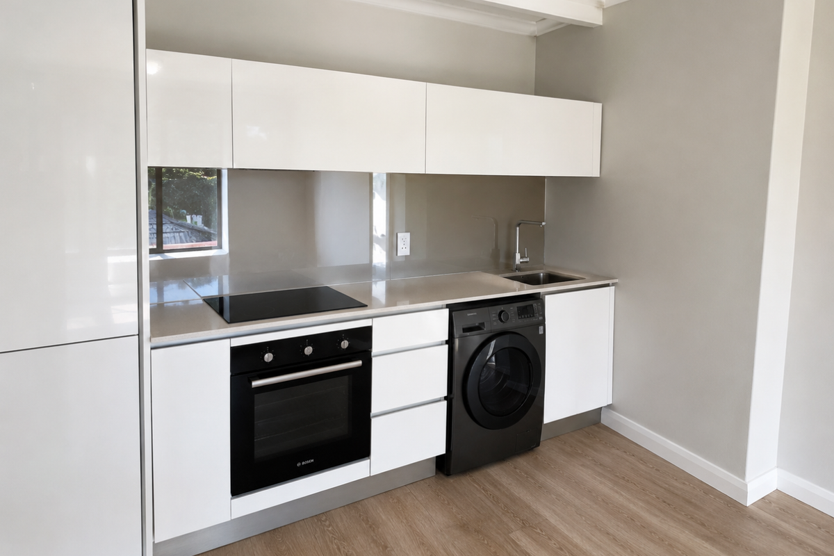 Modern kitchen featuring gloss white cabinetry, stone countertops, integrated oven, electric hob, and a built-in washing machine.