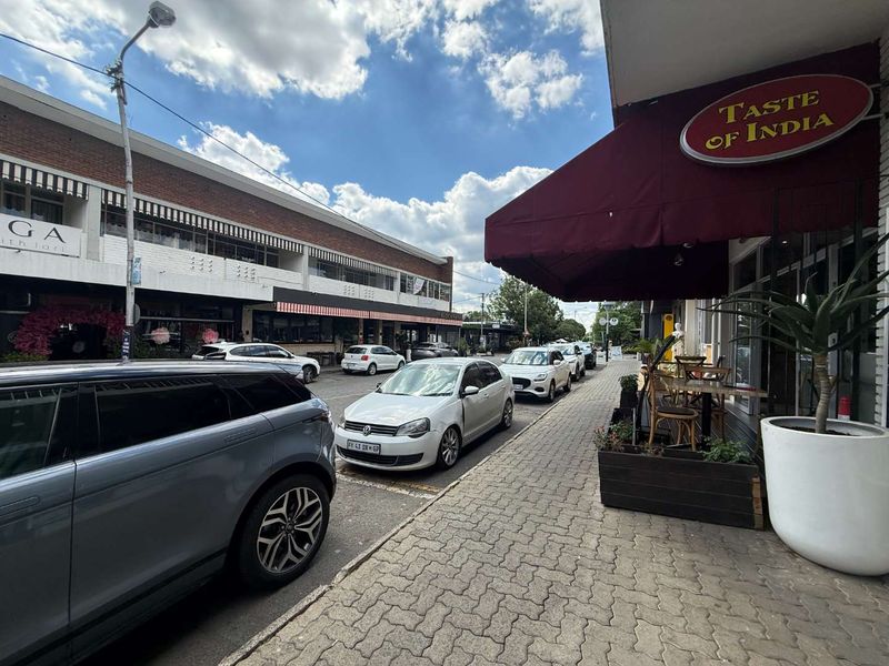 Street-level view of a retail storefront featuring a prominent awning and paved sidewalk access in a commercial area.