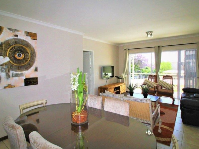 Open-plan living and dining area featuring tiled flooring and large sliding glass doors that provide access to the outdoor space.