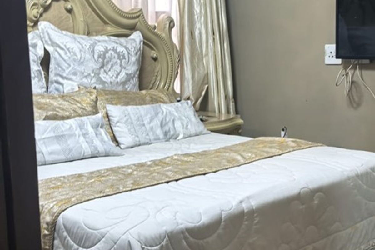 A bedroom featuring laminate flooring and decorative crown molding, providing a comfortable and functional sleeping space.