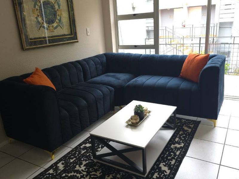 A bright living room featuring neutral tiled flooring, coved ceilings, and large sliding glass doors that provide access to an outdoor area.