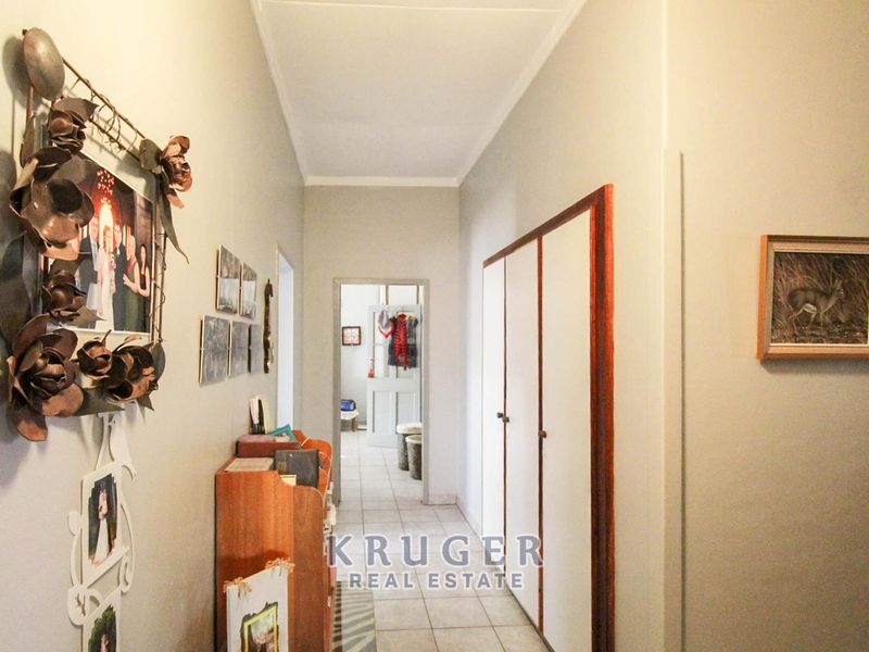 A functional hallway featuring tiled flooring and built-in storage cupboards, providing access to other areas of the home.