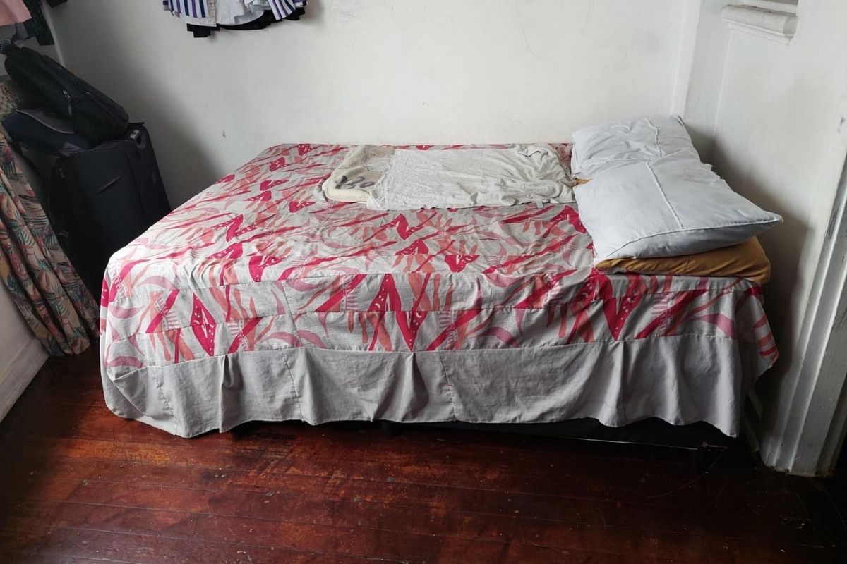 A bedroom featuring original hardwood flooring and plain wall finishes, offering a blank canvas for potential renovation and interior design updates.