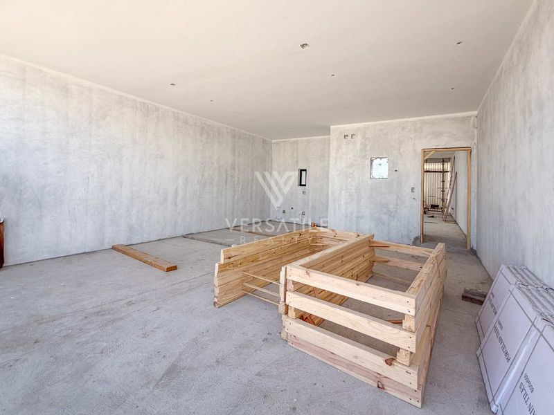 An unfinished open-plan living area featuring raw wall finishes and exposed flooring, ready for final interior fit-out and customization.