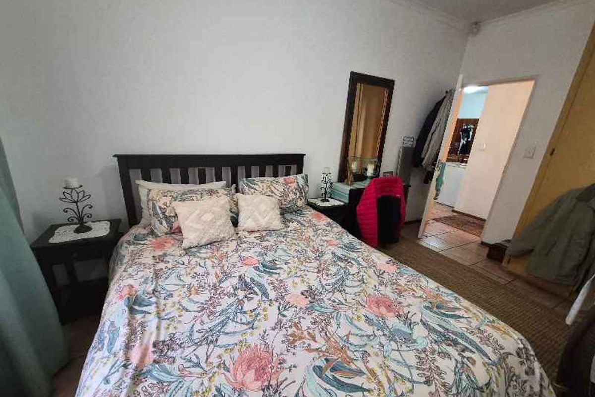 A bedroom featuring built-in cupboards and direct access to an adjacent bathroom area.