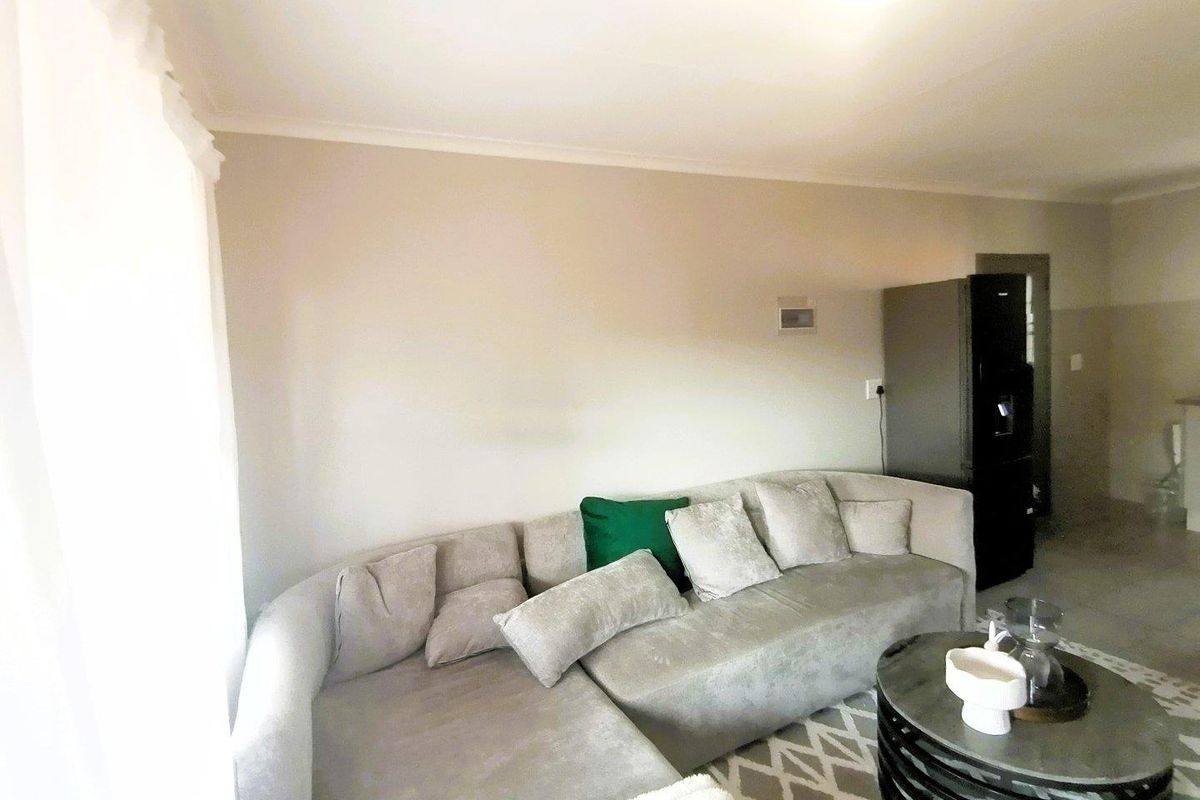 A neutrally painted living room featuring cove cornicing and standard electrical fixtures, providing a clean and functional space for relaxation.