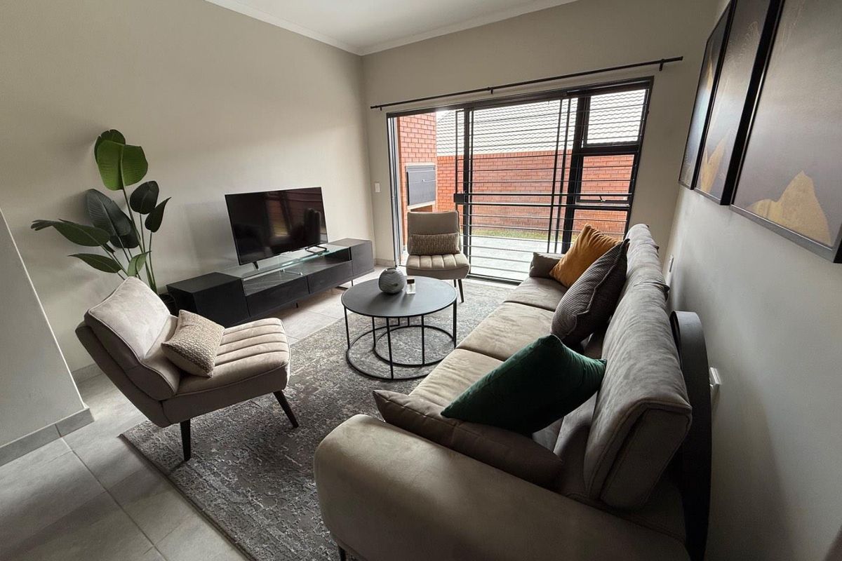 A bright living room featuring large sliding glass doors that provide direct access to an outdoor patio area.