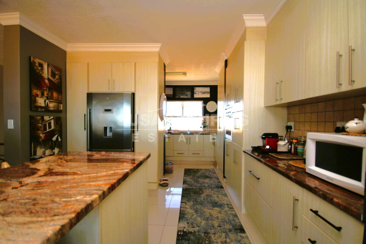 Modern kitchen featuring granite countertops, ample cabinetry, and a central island, creating a functional and stylish culinary space.