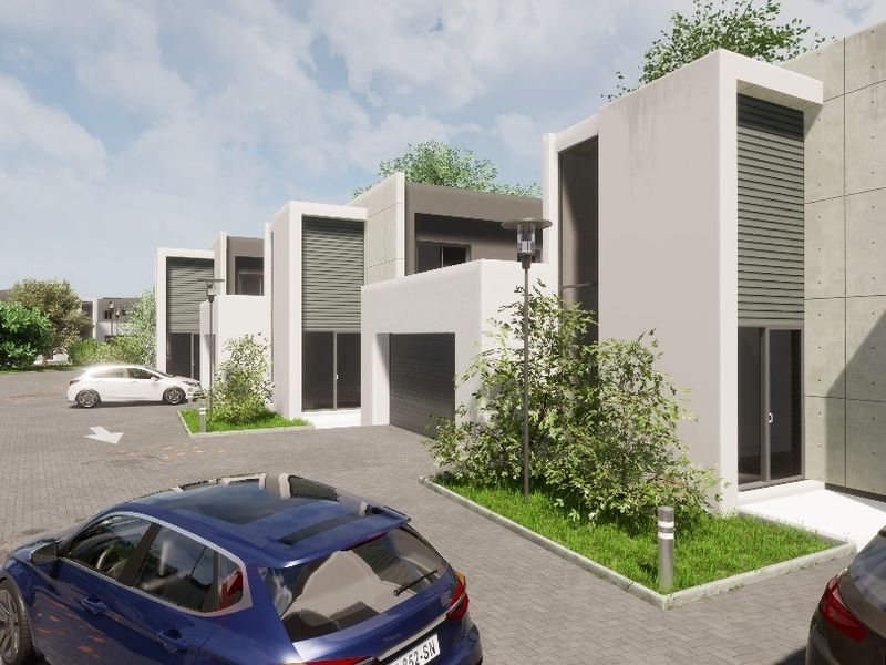 A modern residential complex featuring contemporary architectural design, paved driveways, and integrated garage access.