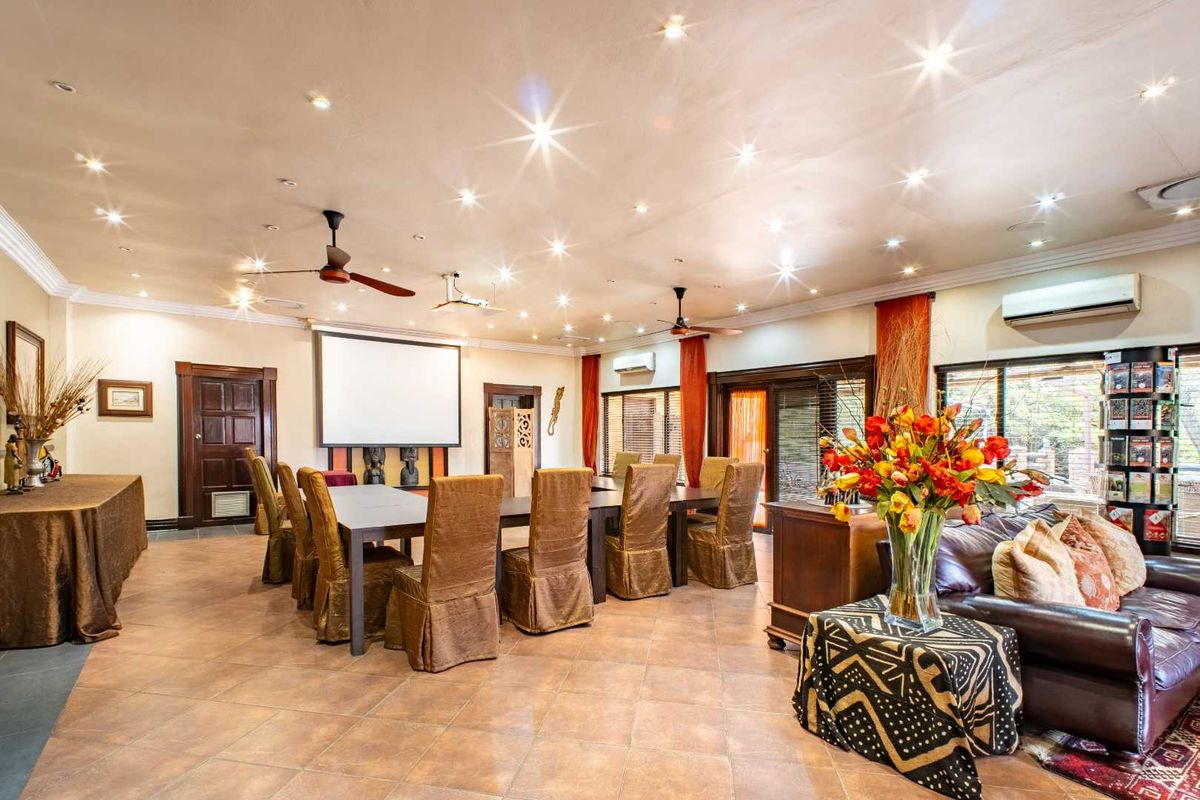 Spacious living area featuring tiled flooring, recessed downlighting, ceiling fans, and integrated air conditioning units, suitable for entertainment or large gatherings.
