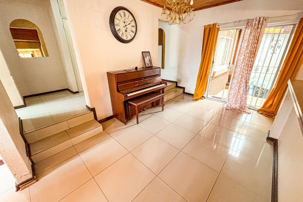 A living area featuring tiled floors, a timber ceiling, and a sliding glass door providing access to the exterior.