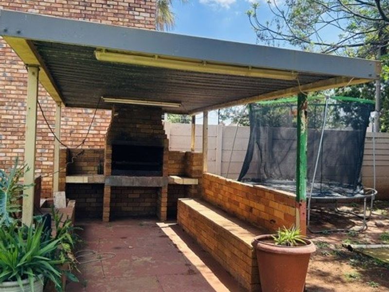 Outdoor covered patio area featuring a built-in brick braai and integrated brick seating, providing a functional space for outdoor entertaining.