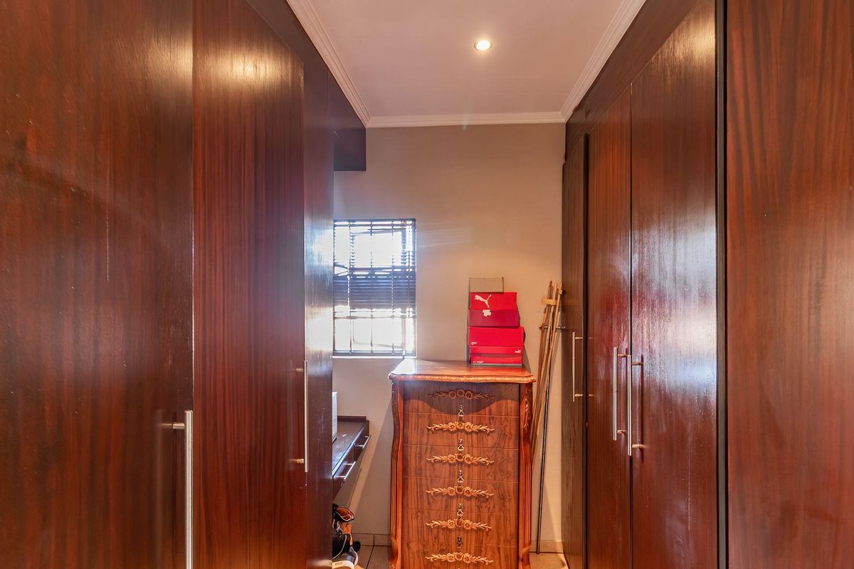 A walk-in closet featuring extensive floor-to-ceiling dark wood cabinetry providing ample built-in storage space.