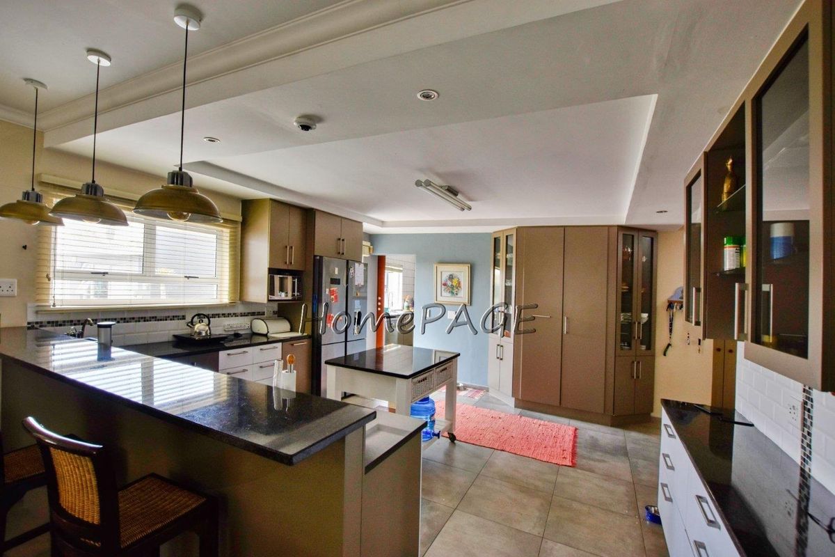 Spacious kitchen featuring granite countertops, built-in cabinetry, a breakfast bar, and recessed ceiling lighting.