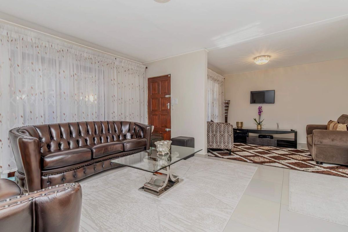 A spacious living area featuring tiled flooring and neutral wall finishes, providing a comfortable and functional space for relaxation.