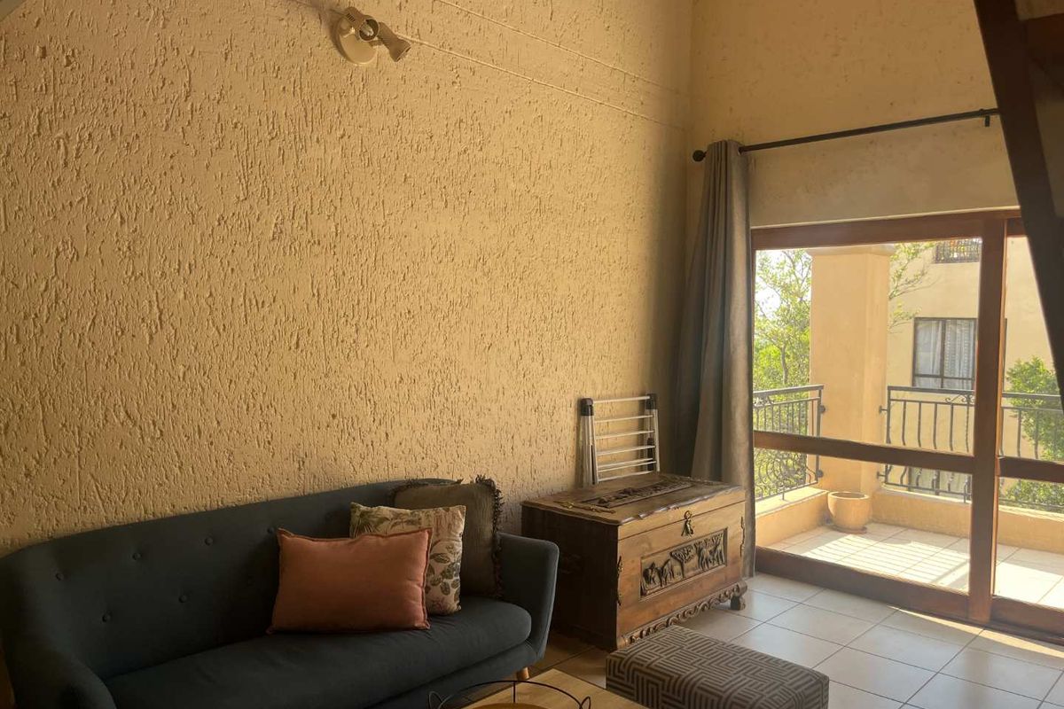 Living room featuring tiled flooring, textured walls, and a sliding glass door providing direct access to an outdoor balcony area.