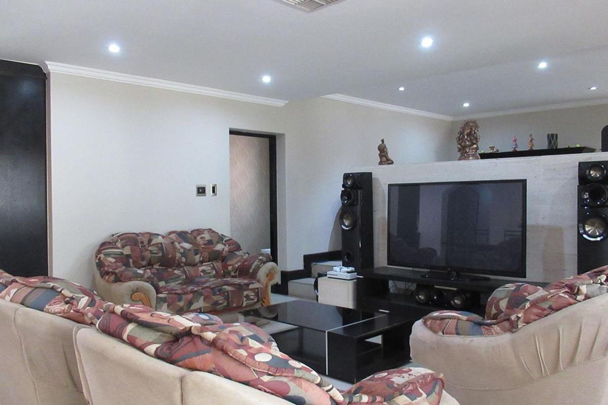 Spacious living room featuring recessed downlighting, crown molding, and a central feature wall partition.