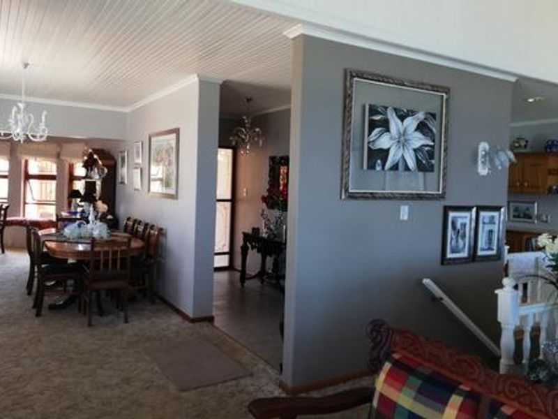 Spacious open-plan living and dining area featuring a beadboard ceiling and neutral wall tones, providing a versatile layout for family living.