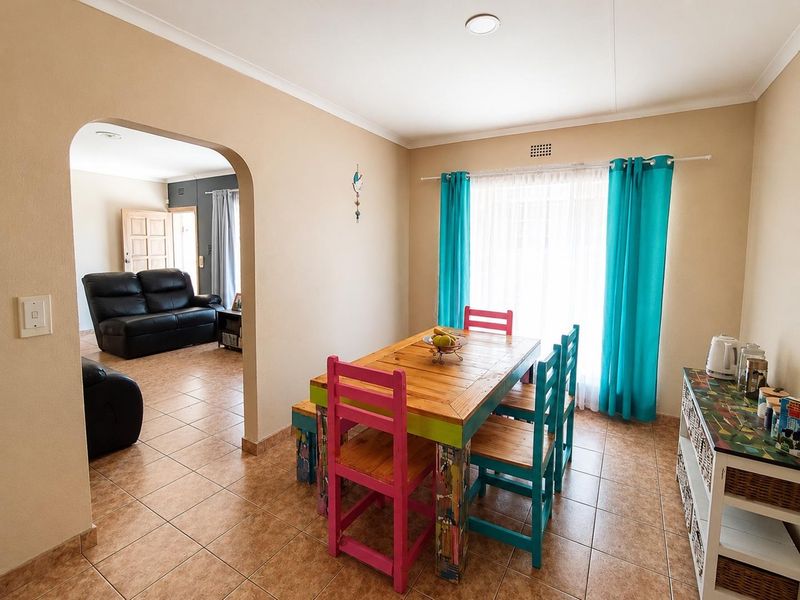 A functional dining area featuring tiled flooring and an arched entryway leading to the adjacent living space.
