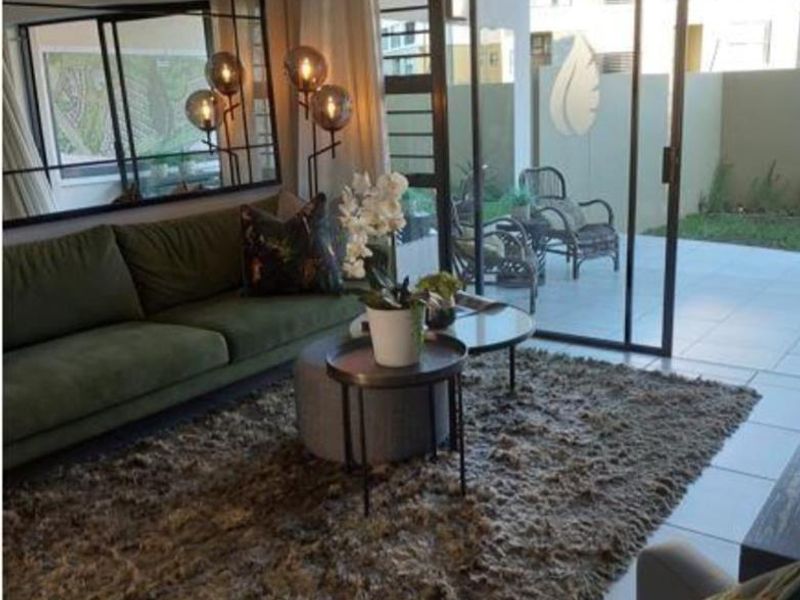 A well-maintained living room featuring large sliding glass doors that provide natural light and direct access to an outdoor patio area.