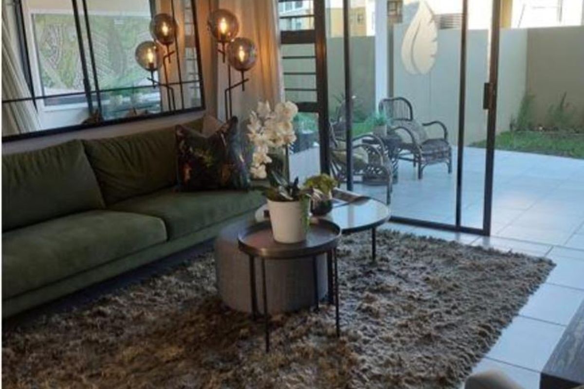A well-maintained living room featuring large sliding glass doors that provide natural light and direct access to an outdoor patio area.
