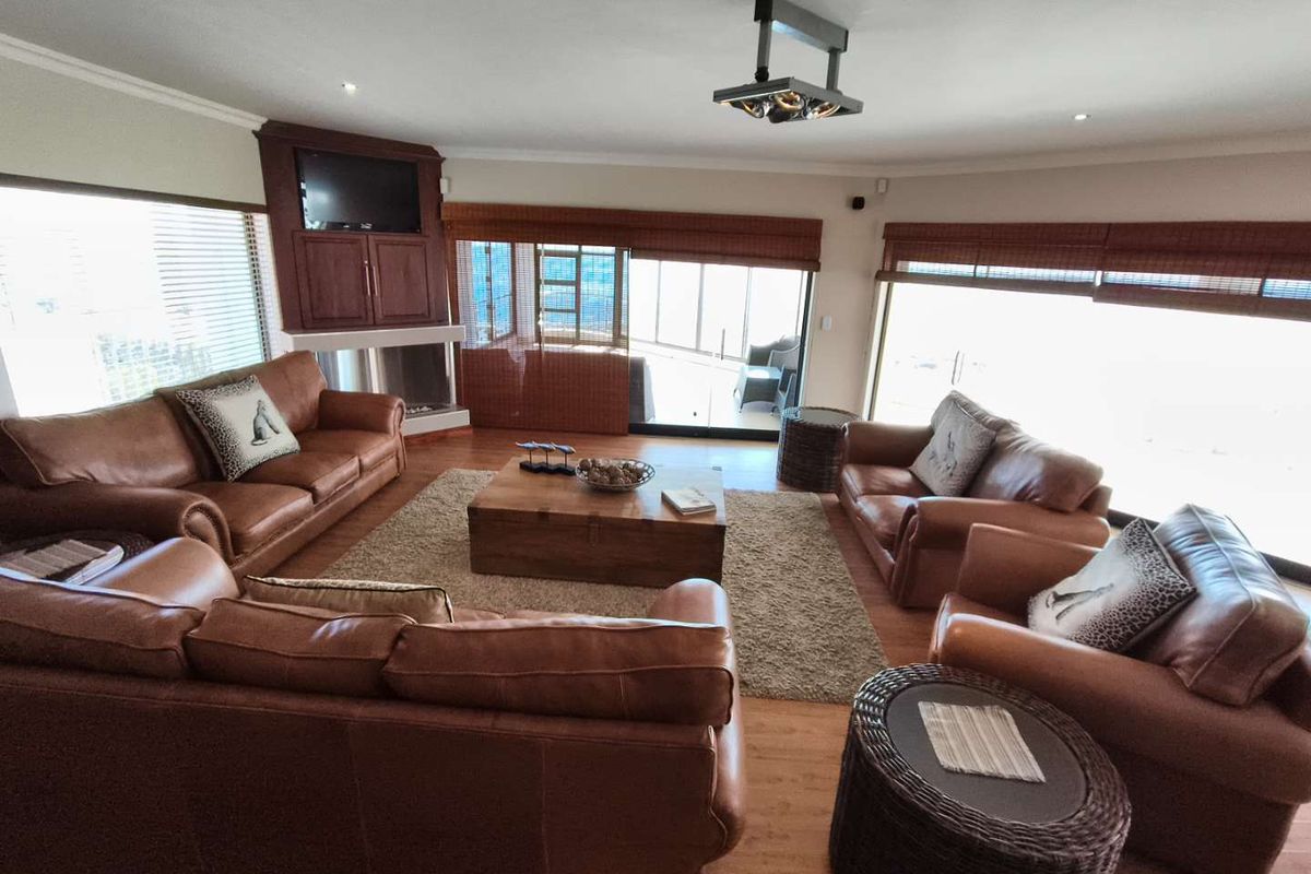 Spacious living room featuring laminate flooring, a built-in fireplace with integrated cabinetry, and large sliding glass doors leading to an outdoor area.