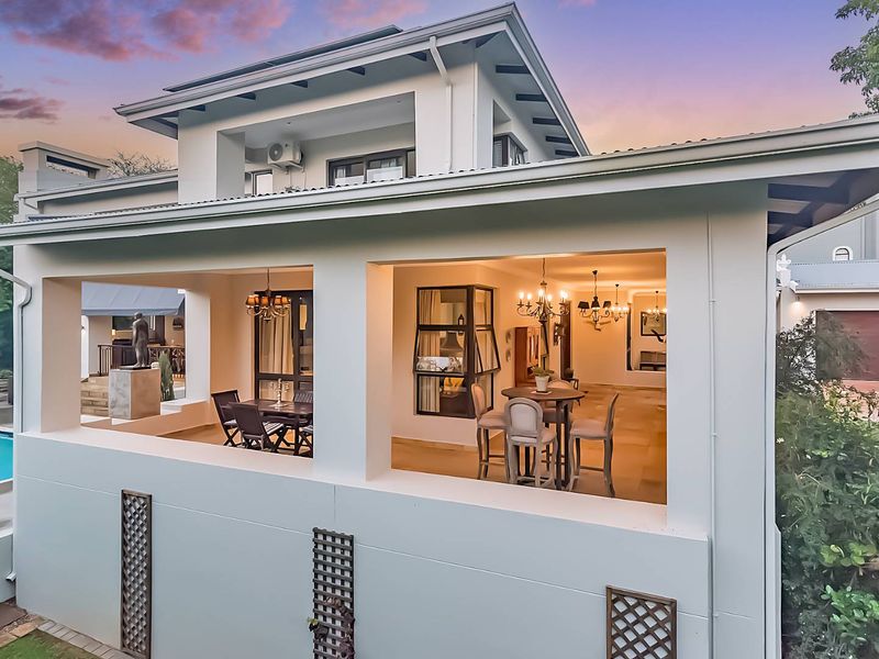 Spacious covered patio area featuring tiled flooring and direct access to the garden and pool, ideal for outdoor entertaining.