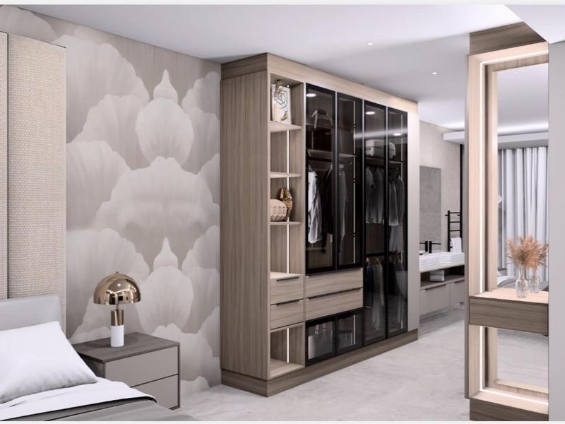 Modern bedroom featuring high-end built-in cabinetry with glass-fronted wardrobes, integrated shelving, and sophisticated recessed lighting.